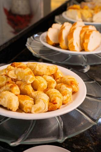 a plate of food on a table with plates of pastries at Pousada Aeroporto in Parnaíba