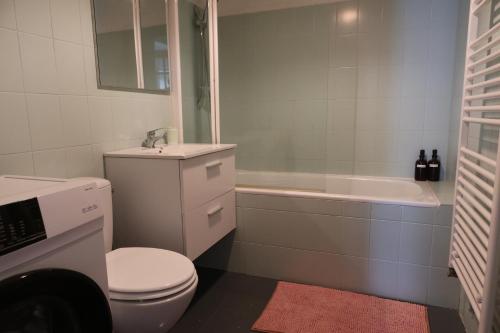 Un baño con inodoro, lavabo y bañera. en * La Tour : Vue imprenable sur la ville *, en Luxeuil-les-Bains
