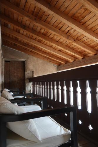 een groep bedden in een kamer met houten plafonds bij * La Tour : Vue imprenable sur la ville * in Luxeuil-les-Bains