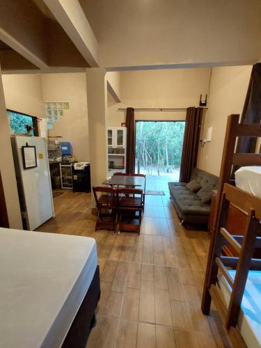 eine Küche und ein Wohnzimmer mit einem Tisch und einem Kühlschrank in der Unterkunft Recanto Gira Cerrado in Cavalcante