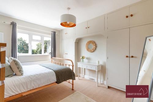 a white bedroom with a bed and a window at Maidenhead - 4 Bedroom House With Driveway & Garden in Maidenhead