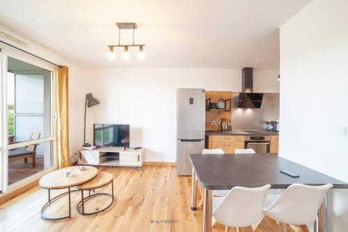 une cuisine et une salle à manger avec une table et des chaises dans l'établissement Appartement piscine + parking bregille, à Chalezeule