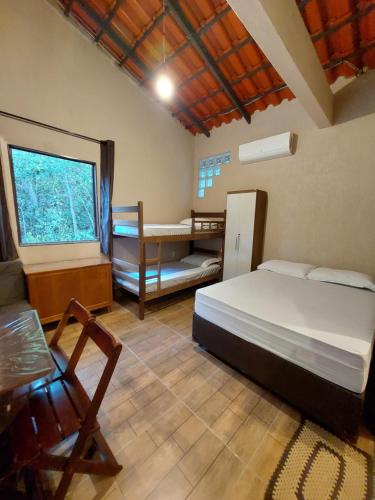 a bedroom with a bed and a desk and a window at Recanto Gira Cerrado in Cavalcante