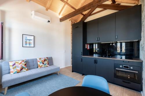 a living room with a couch and a kitchen at VIVA Serralves Vintage House in Porto