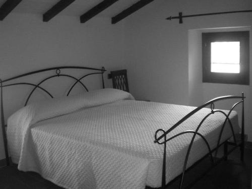 a bedroom with a white bed with a window at Locanda dei Fienili del Campiaro in Grizzana