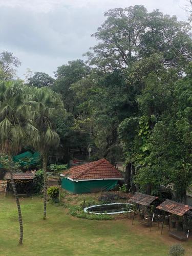 een uitzicht op een tuin met een gebouw en bomen bij Jewel Resort in Lonavala