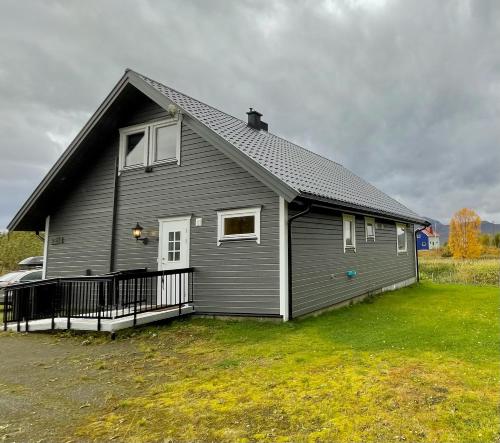 a gray house with a black roof on a yard at Cozy house in an Arctic village 