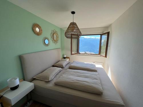 1 dormitorio con 1 cama grande y ventana en Cozy 2-bedroom appartment, lovely mountain escape en Crans-Montana