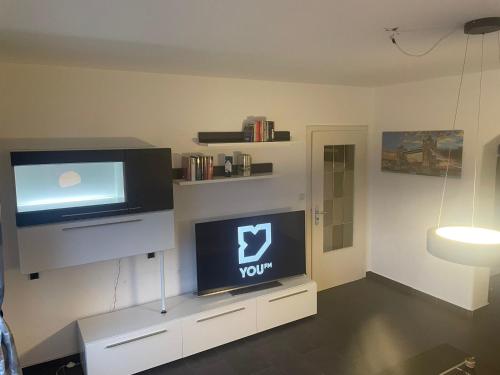 ein Wohnzimmer mit einem Flachbild-TV auf einem Stand in der Unterkunft FewoLINDE OG in Olpe