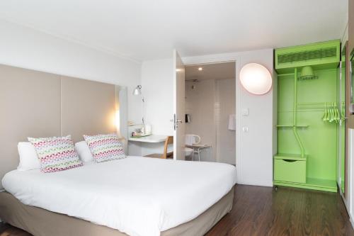 1 dormitorio con cama blanca y pared verde en Campanile Créteil - Bonneuil Sur Marne, en Bonneuil-sur-Marne