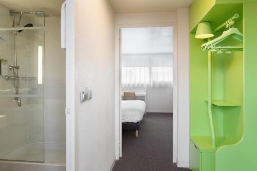 a bathroom with a shower and a room with a bed at Campanile Créteil - Bonneuil Sur Marne in Bonneuil-sur-Marne