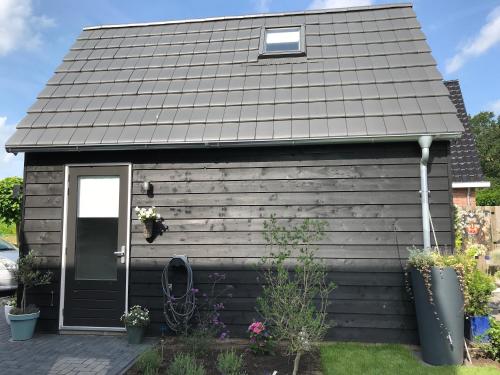 a small house with a black roof at B&B de Waander 