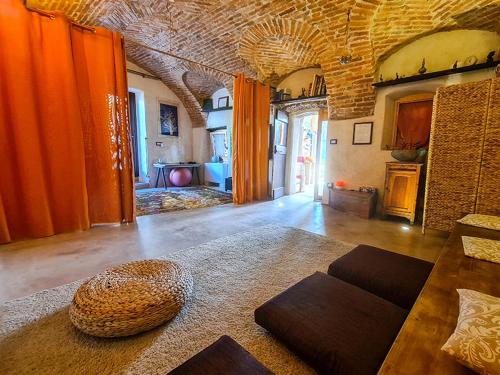 uma sala de estar com cortinas cor de laranja e um quarto com um sofá em CasaRosada WITH WELLNESS & SPA EXTRA em Vidracco