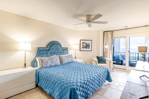 a bedroom with a blue bed and a balcony at Sea Cloisters 409 in Hilton Head Island
