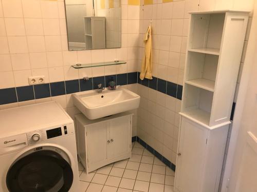uma casa de banho com uma máquina de lavar roupa e um lavatório em Charmante Altbau-DG-Wohnung em Munique