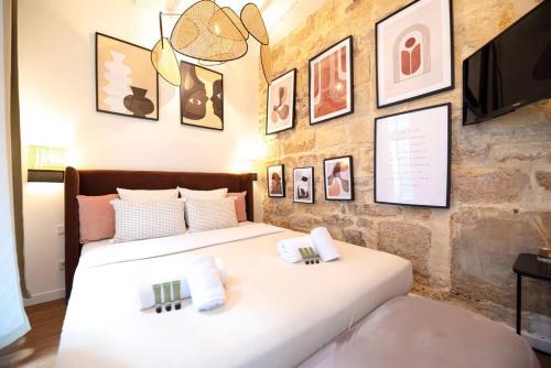 - 2 lits dans une chambre avec des photos sur le mur dans l'établissement CIA - CENTRAL LE MARAIS, à Paris