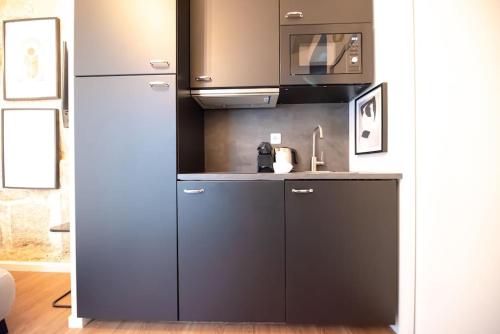 une cuisine avec un réfrigérateur et un micro-ondes dans l'établissement CIA - CENTRAL LE MARAIS, à Paris