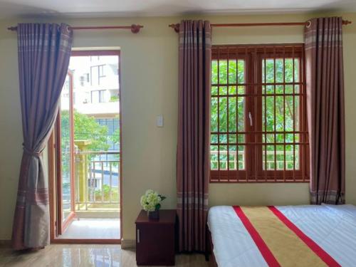 a bedroom with a bed and a large window at Hoa Sua Hotel in Vung Tau
