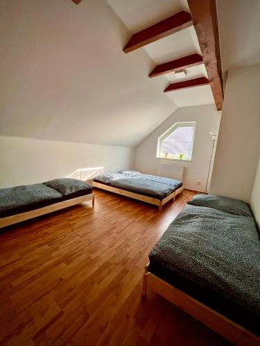 Habitación con 2 camas y suelo de madera. en Ubytování v Kyjově, en Kyjov