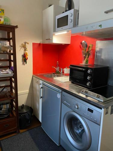 une cuisine avec un lave-linge et un micro-ondes dans l'établissement Studio sans chambre Soustons plage proximité golf océan, à Soustons
