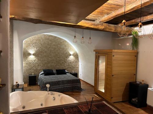 Schlafzimmer mit einem Bett und einer Badewanne in der Unterkunft Relais il Duomo con SPA privata in Sutri