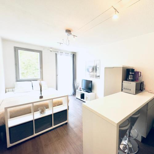 Cette chambre blanche comprend un lit et un bureau. dans l'établissement *Le CityZen*15min du centre à pied+parking gratuit, à Annecy