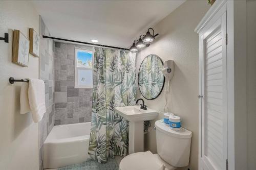 a bathroom with a sink toilet and a shower curtain at Bungalow by the Bay in Sarasota