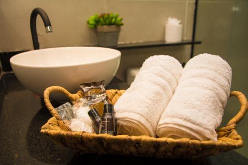 a basket with towels and a sink in a bathroom at Pousada Gaucha in Fernando de Noronha