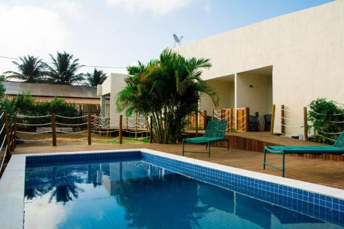 uma piscina com duas cadeiras ao lado de uma casa em Pousada Gaucha em Fernando de Noronha