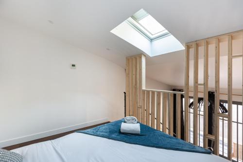 une chambre avec un lit et une lucarne dans l'établissement Le Maupassant - Appt en mezzanine, à Bordeaux