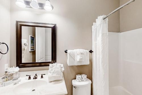 a bathroom with a sink and a toilet and a mirror at North Beach Villas 201 in Myrtle Beach