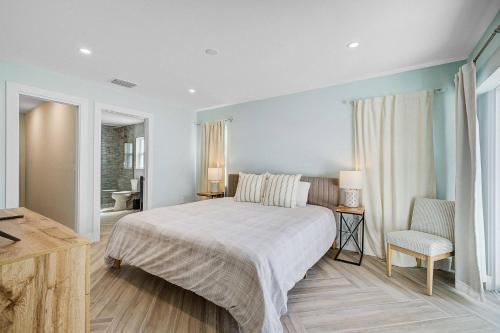 ブレーデントンにあるTranquil Breezeの大きなベッドと椅子のある寝室