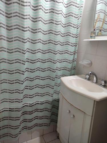 a bathroom with a shower curtain and a sink at Departamento céntrico en San Nicolas IG martindebra22 in San Nicolás de los Arroyos