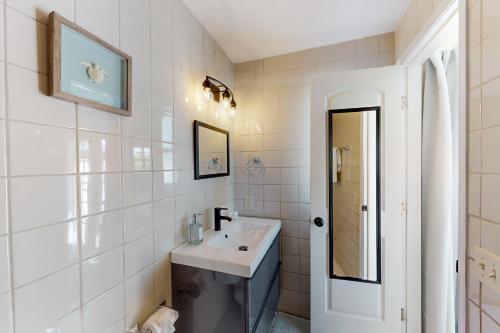 uma casa de banho branca com um lavatório e um espelho em Lounging Palms Estate em Fort Myers