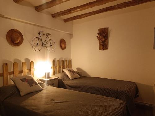 a bedroom with two beds and a bike on the wall at Apartament Turístic Campdevànol in Campdevánol