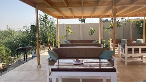 a covered patio with a couch and a table at Royal Nile Villa - Nile View Apartment 1 in Luxor