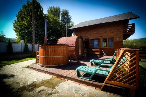 - un ensemble de chaises assises sur une terrasse en face d'une maison dans l'établissement La Cabane Râșnov, à Râșnov