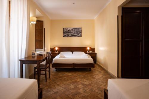 a bedroom with a bed and a desk and a table at Casa I Cappuccini in Rome