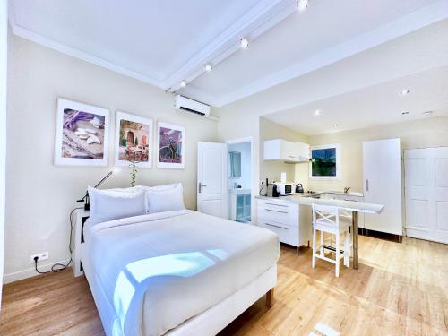une chambre blanche avec un lit et une cuisine dans l'établissement Èrsextius, MG, Aix-en-Provence, à Aix-en-Provence