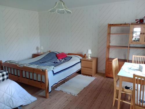 a bedroom with a bed and a table in it at Gammal stil in Fröseke