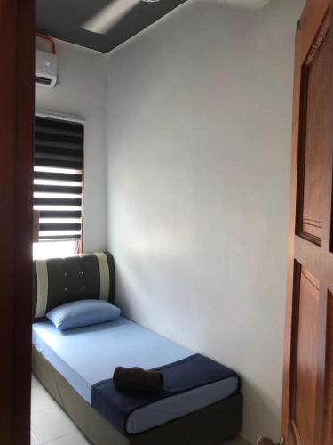 a small bed in a room with a window at Aja Retreat Homestay OnlyMuslim in Jitra