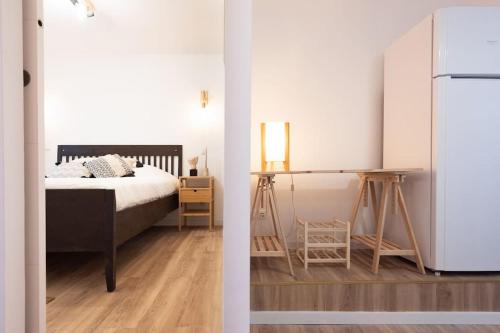 波多的住宿－L'Atelier - Warm Porto Loft，一间卧室配有床和白色冰箱