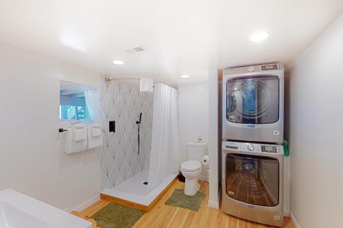 ein Badezimmer mit einer Waschmaschine und einem Trockner neben einem WC in der Unterkunft Skyline Ridge in Crestline
