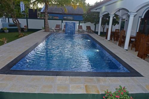 a large pool with blue water in a yard at Sri Ra'anana Villa in Marawila