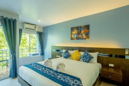 a bedroom with a large bed with blue walls at The Great @Patong Hotel in Patong Beach