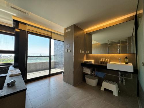 a bathroom with a sink and a large window at Sunrise Hot Spring House in Toucheng