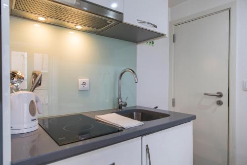 uma cozinha com um lavatório e um micro-ondas em 133 B - My lovely house in Alfama with AC em Lisboa