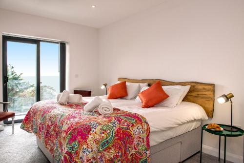 a bedroom with a bed and a large window at Cormorant in Torpoint