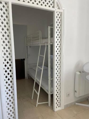 a white bunk bed with a ladder in a room at Blife Sun Hostel & Rooms in Faro