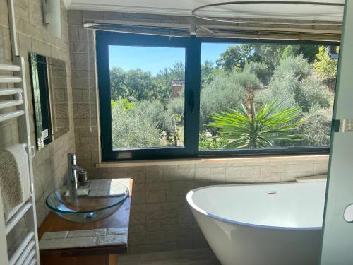 bagno con vasca, lavandino e finestra di Relaxscape a Tomar